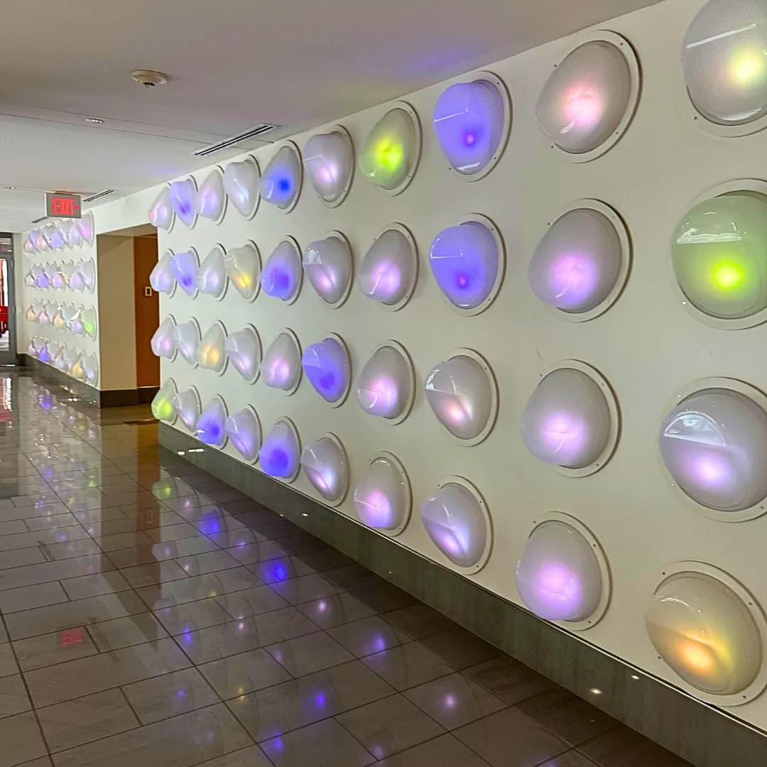 A corridor wall of glowing, color-shifting light domes in the Des Moines skywalk