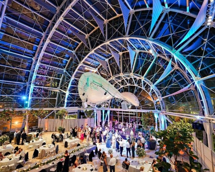 The Artsgarden dome at night, lit blue for a wedding reception above the intersection