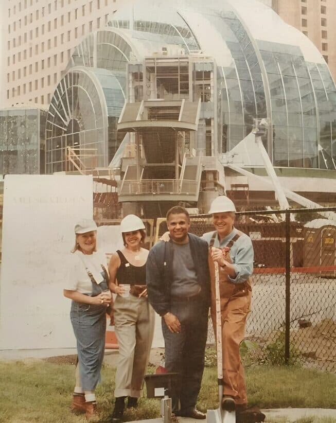 Architect Walter S. Blackburn and colleagues in hard hats in front of the Indianapolis Artsgarden's glass dome under construction, 1995