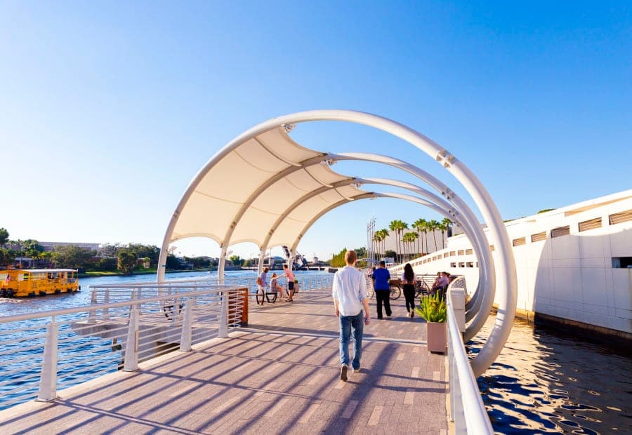 A canopied over-water section of the Tampa Riverwalk curving past the convention center
